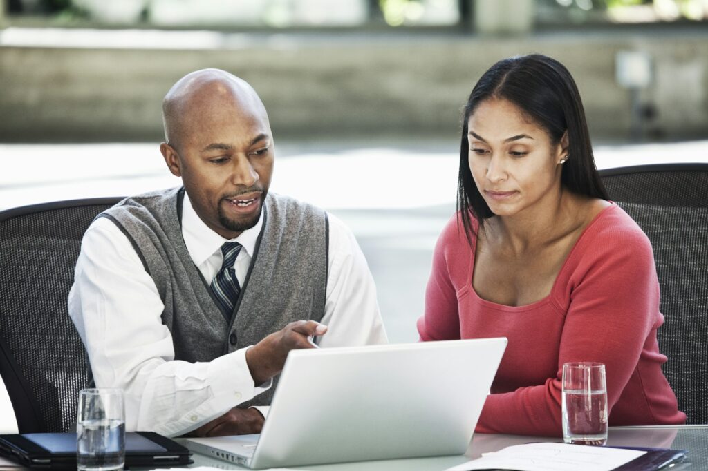 Black business man and mixed race caucasian woman in a business center meeting.
